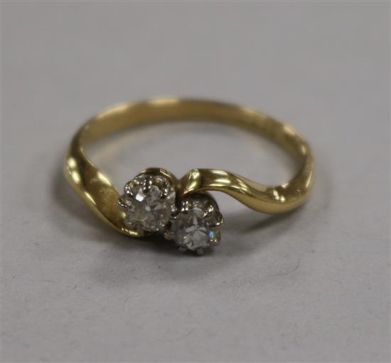 An 18ct gold and two stone diamond crossover ring, size M.